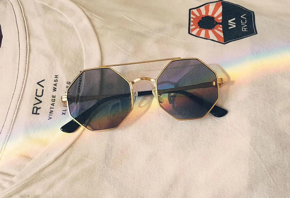 Beautiful cat eye glasses with colored lenses and gold frames, stylish eyewear on fabric